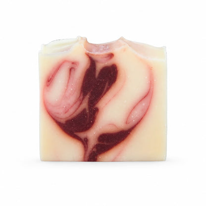 A rectangular bar of Jarhead Aromatics Citrus + Patchouli Handmade Natural Tallow Artisan Soap features a cream base with swirled red and dark pink patterns resembling abstract flowers, set against a white background. This Bright Citrus & Earthy Patchouli Soap masterfully combines beauty with craftsmanship for a truly unique bathing experience.