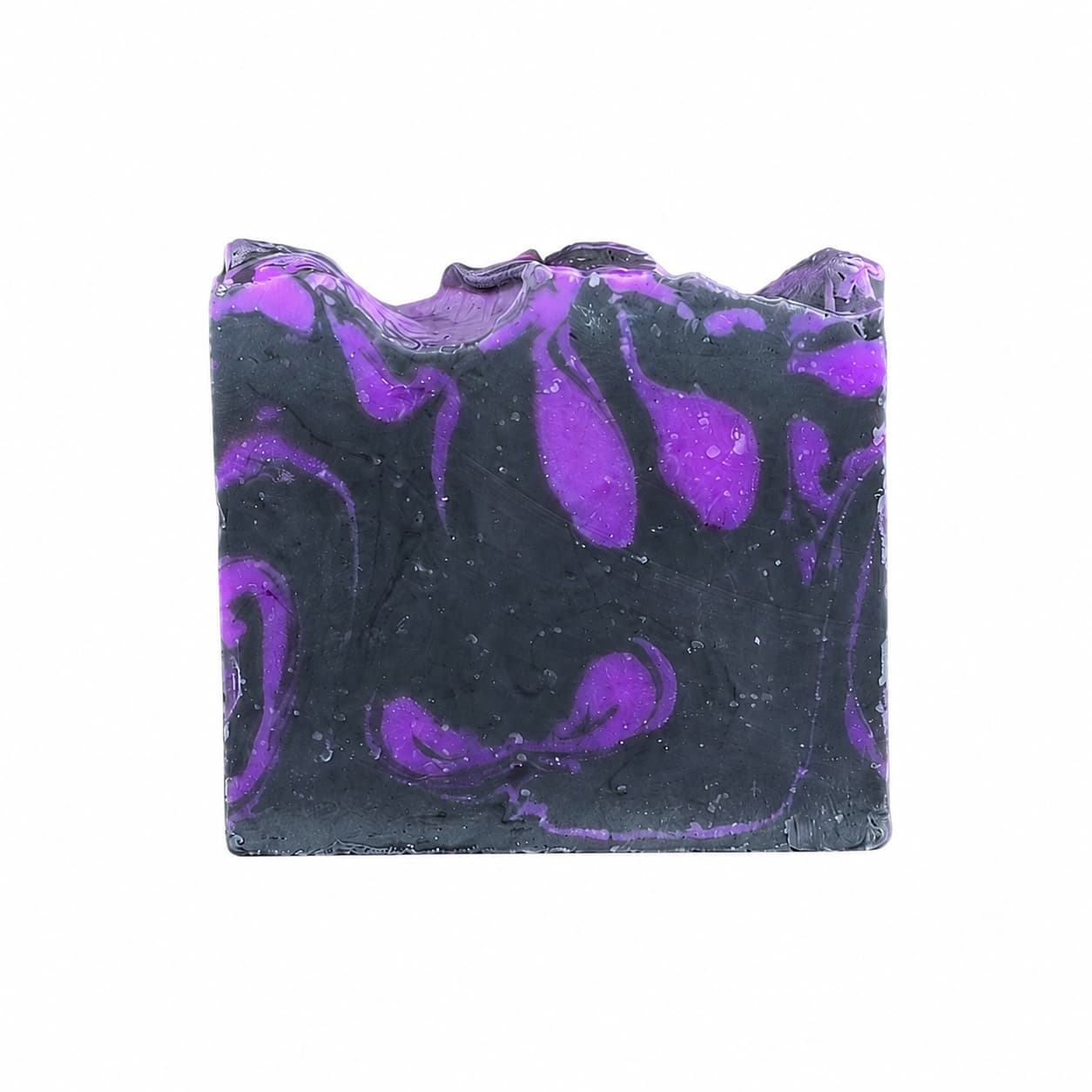 Displayed against a white background is a rectangular bar of Jarhead Aromatics Citrus + Sandalwood Handmade Coconut Milk Artisan Soap, featuring a black base color with swirling purple patterns. This artisan soap blends bright citrus and woodsy sandalwood fragrances, offering both striking visual appeal and luxurious coconut milk skincare benefits.