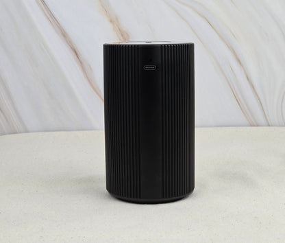 The Jarhead Aromatics Cold Air Diffuser - Portable & Rechargeable features a black cylindrical design with vertical grooves, a charging port near the top, and an earthy look—perfect for diffusing essential oils anywhere.