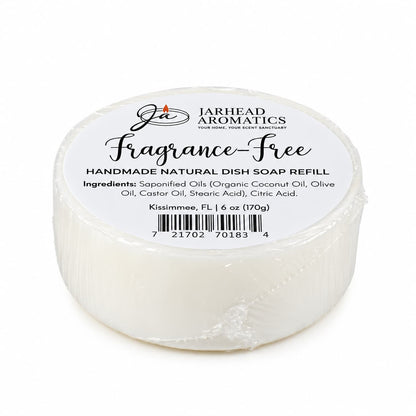Round, plastic-wrapped bar of white, fragrance-free Fragrance-Free Handmade Natural Solid Dish Soap, featuring a label that lists ingredients and weight.