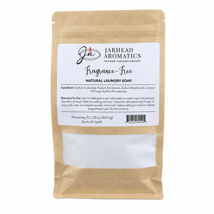 A brown paper bag labeled Jarhead Aromatics Fragrance-Free Handmade Natural Laundry Soap | Unscented Powdered Laundry Detergent, displaying ingredients and directions, with a window showing the white powdered soap inside. This handmade laundry detergent comes in a 32 oz package and is sufficient for up to 64 loads.