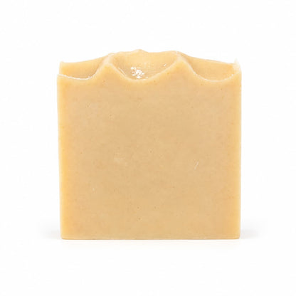An upright rectangular bar of Jarhead Aromatics Frankincense + Citrus Handmade Natural Tallow Artisan Soap, beige in color with an uneven wavy top edge, is displayed on a white background.