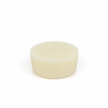 A plain, round, off-white solid object with smooth sides and top, resembling a bar of soap, sits centered on a white background—this is the Lemon Handmade Natural Solid Dish Soap by Jarhead Aromatics, an elegant and eco-friendly citrus kitchen cleaning bar infused with lemon essential oil.