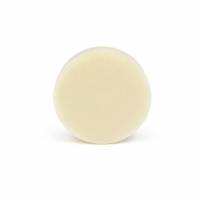 A round, cream-colored solid bar of Lemon Handmade Natural Solid Dish Soap from Jarhead Aromatics—featuring invigorating lemon essential oil—is centered against a plain white background.