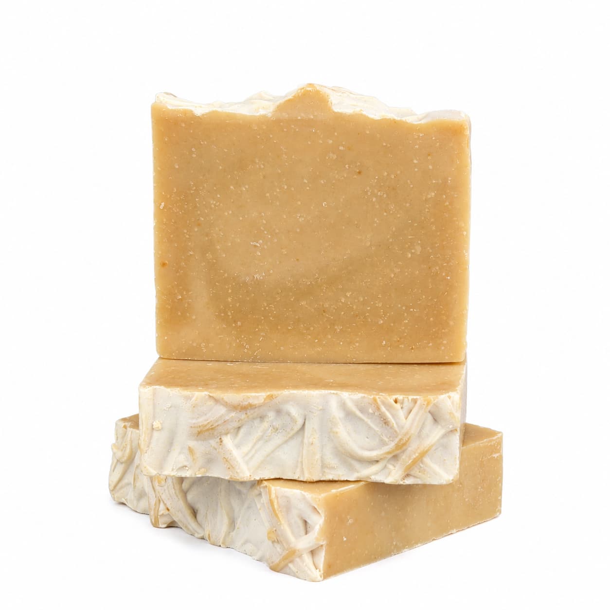 Three Jarhead Aromatics “IPA + Pine Handmade Craft Beer Artisan Soap” bars are stacked against a white background. The top bar, featuring a tan color and rough edge, sits above two bars whose cream-colored swirled patterns accent their tops and sides. Each soap is crafted with citrus, pine, and hops for an artisan touch.