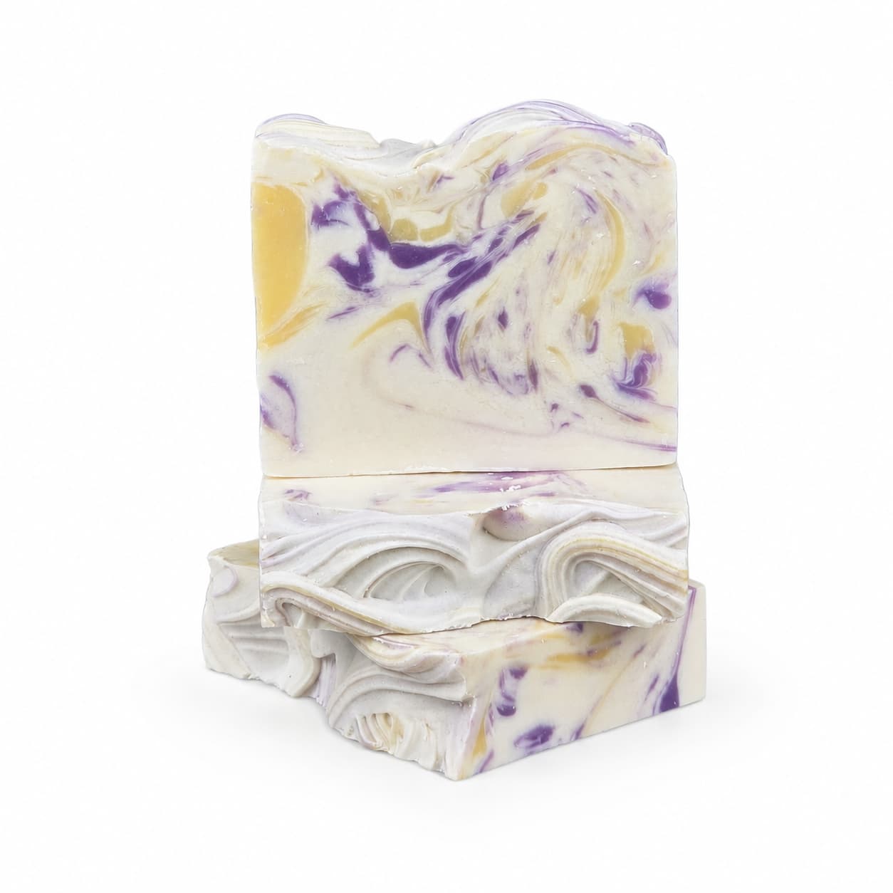 Two bars of Jarhead Aromatics Lavender + Lemon Handmade Coconut Milk Artisan Soap, showcasing wavy textures and elegant swirled patterns in white, purple, and yellow hues, are stacked against a white background. This calming lavender and bright lemon soap artfully combines beautiful design with luxurious coconut milk ingredients.