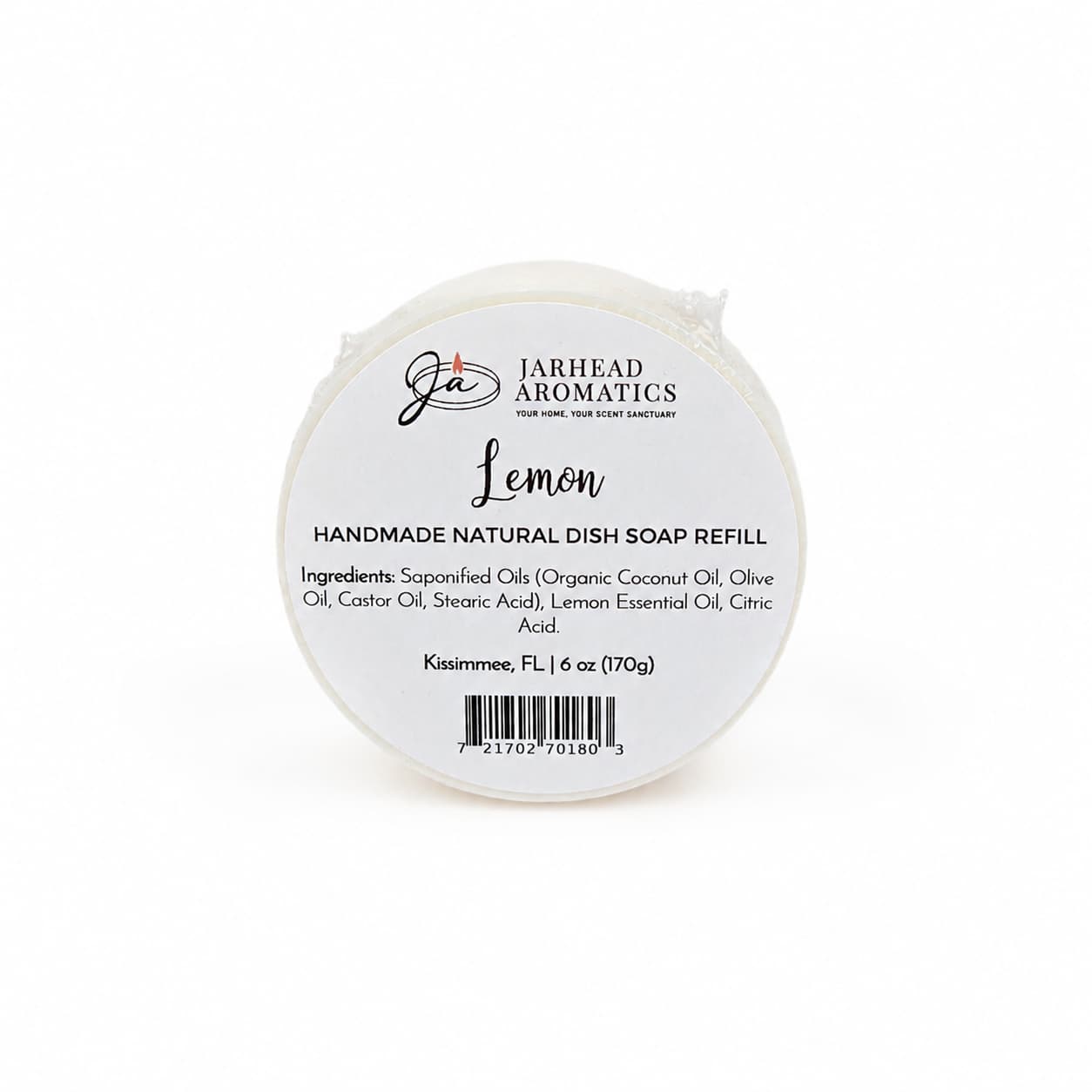 A round white soap bar labeled "Jarhead Aromatics Lemon Handmade Natural Solid Dish Soap | Citrus Kitchen Cleaning Bar with Lemon Essential Oil," featuring a list of ingredients, weight (6 oz), barcode, and citrus scent details. This plant-based lemon solid dish soap is ideal for kitchen cleaning.