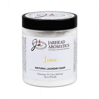 A clear jar labeled Jarhead Aromatics Lemon Handmade Natural Laundry Soap, topped with a black lid. Inside is powdered detergent made by hand and scented with fresh lemon essential oil. The 16 oz jar provides enough for up to 32 loads.