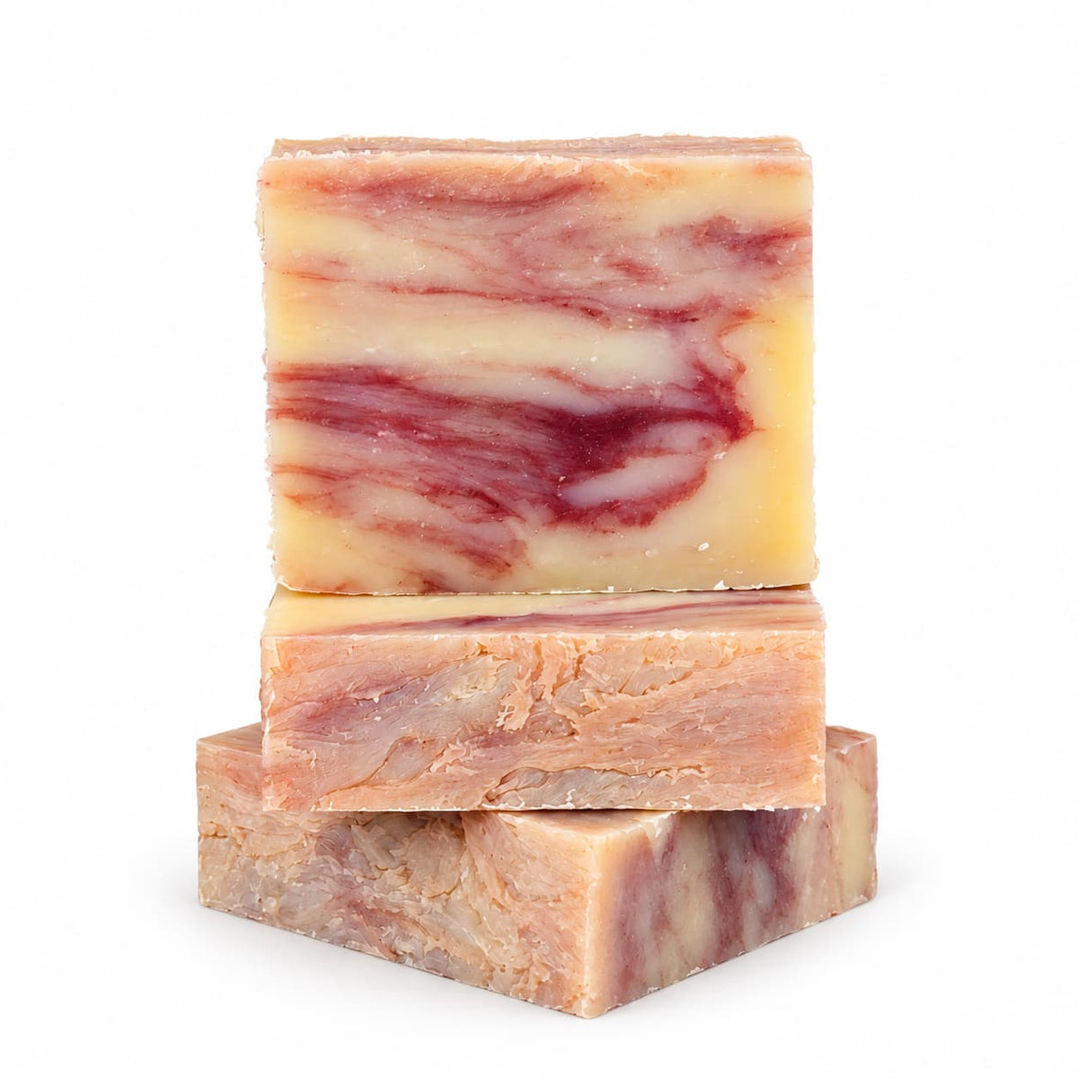 Three bars of Lemongrass + Clary Sage Natural Handmade Soap stacked on top of one another, each with a marbled pattern of cream, tan, and reddish-purple swirls.