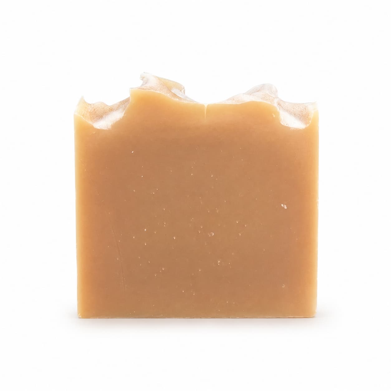 A rectangular bar of Jarhead Aromatics Lemongrass Handmade Natural Goat Milk Artisan Soap, featuring a light brown hue and an uneven, wavy top edge, is displayed against a plain white background.