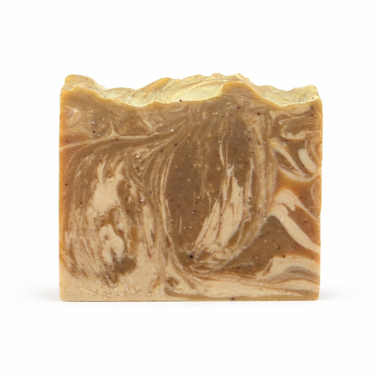 A rectangular bar of Jarhead Aromatics Mahogany + Coconut Handmade Coconut Milk Artisan Soap, featuring marbled brown and beige hues with a rough, uneven top edge, is displayed against a plain white background.