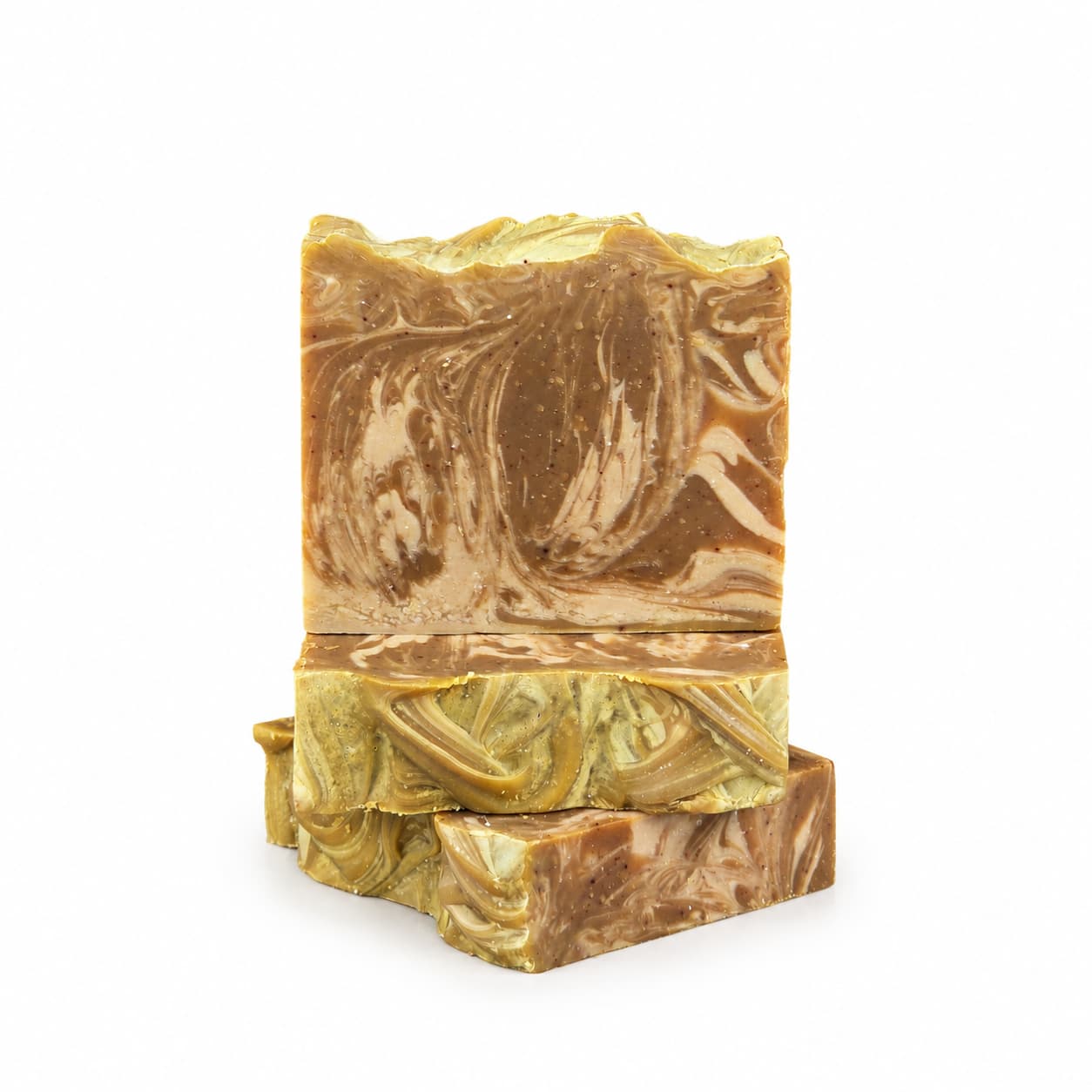 Three handcrafted bars of the Mahogany + Coconut Handmade Coconut Milk Artisan Soap by Jarhead Aromatics are stacked against a white background, highlighting their marbled brown and gold pattern with a beautifully textured, swirled surface design. Indulge in the nourishing qualities of this warm woods and creamy coconut artisan soap collection.