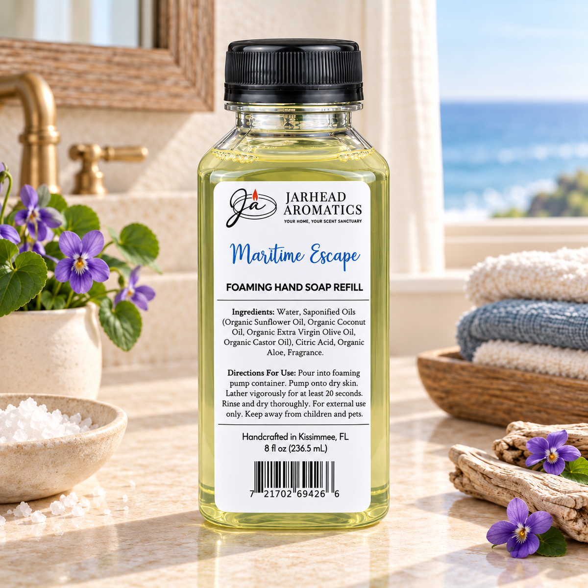 Clear bottle of Maritime Escape Handmade Foaming Hand Soap | Ozone, Sea Salt & Violet refill with a black cap, featuring a white label that lists ingredients, instructions, and a barcode.