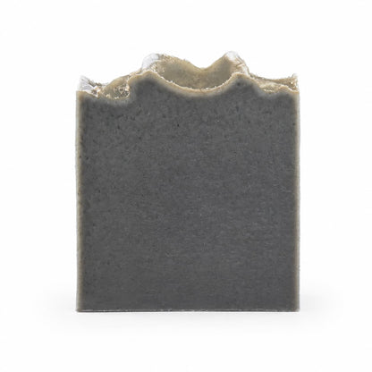 A rectangular, charcoal-gray bar of Mugwort + Lavender Handmade Natural Artisan Soap from Jarhead Aromatics, featuring a rough, uneven top edge, is shown against a plain white background.
