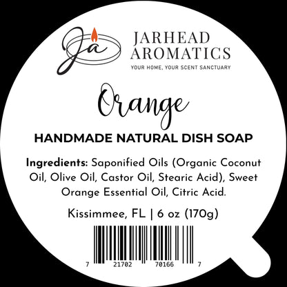 Round label for Jarhead Aromatics Orange Handmade Natural Solid Dish Soap | Citrus Kitchen Cleaning Bar with Essential Oils, showcasing the logo with a flame above the “JA” initials. This plant-based, natural solid dish soap bar clearly displays ingredients and net weight (6 oz), a barcode, and the location: Kissimmee, FL.