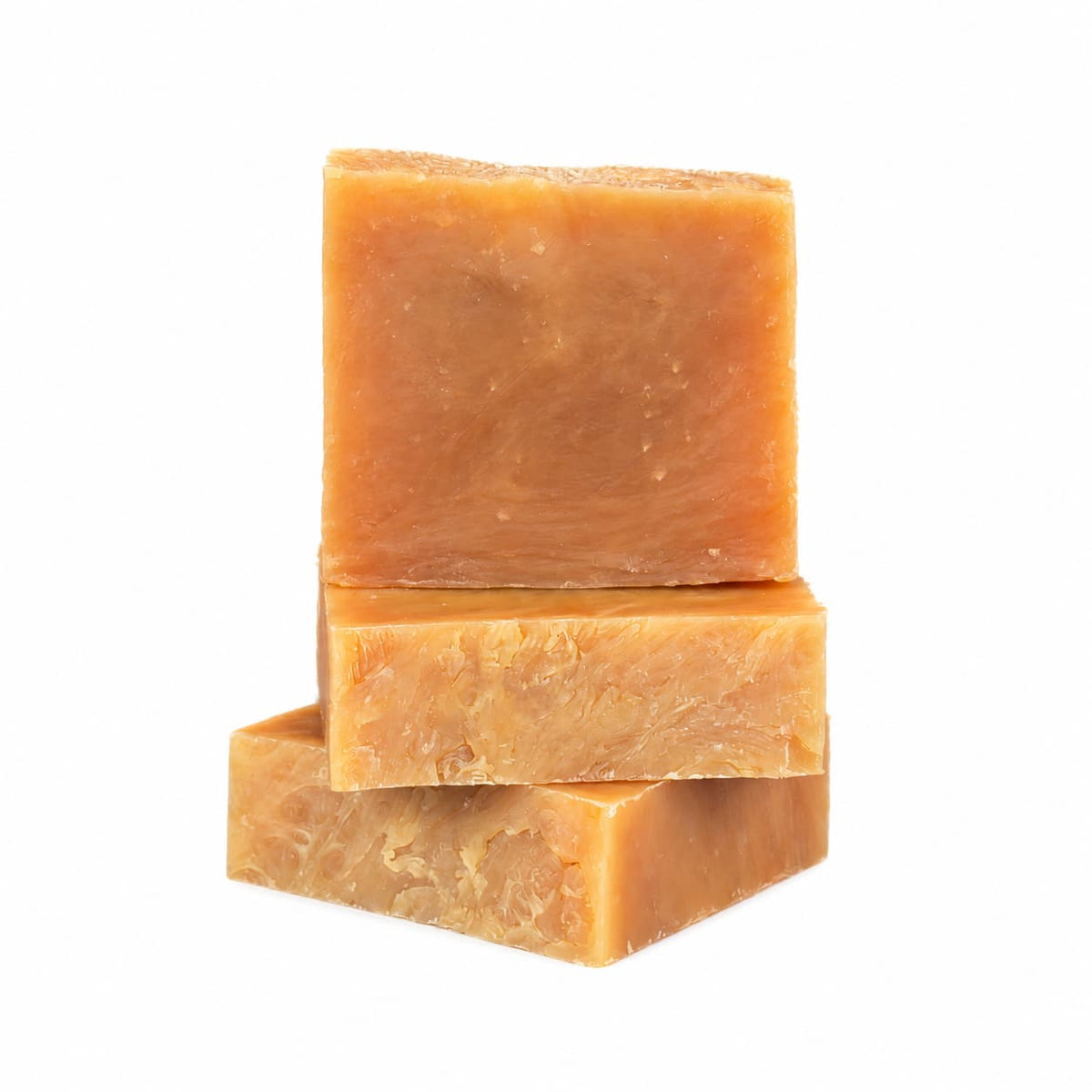 Three rectangular bars of Orange + Lemongrass Natural Handmade Goat Milk Soap stacked on top of each other.