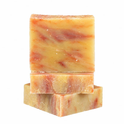 Three rectangular bars of Orange + Lime Natural Handmade Soap with orange and red marbling stacked vertically.
