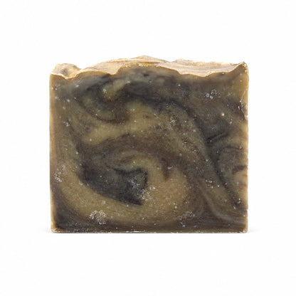 A handcrafted square bar of Jarhead Aromatics Palo Santo + Patchouli Handmade Artisan Soap, featuring a marbled swirl design in shades of brown, beige, and black charcoal, is displayed against a white background.