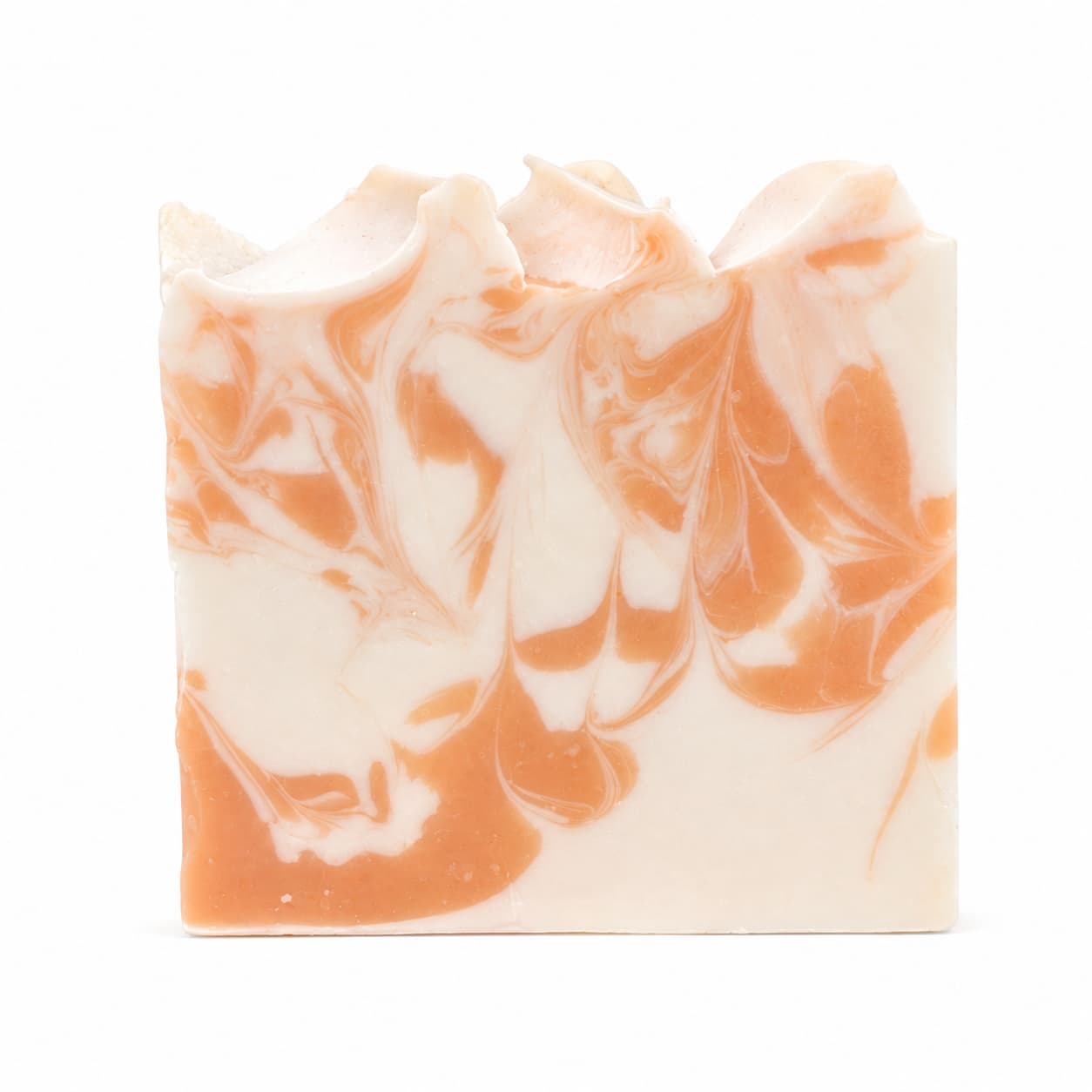 A rectangular bar of Jarhead Aromatics Peach + Magnolia Handmade Coconut Milk Artisan Soap features a marbled pattern of cream and orange swirls with wavy, uneven top edges, set against a plain white background.