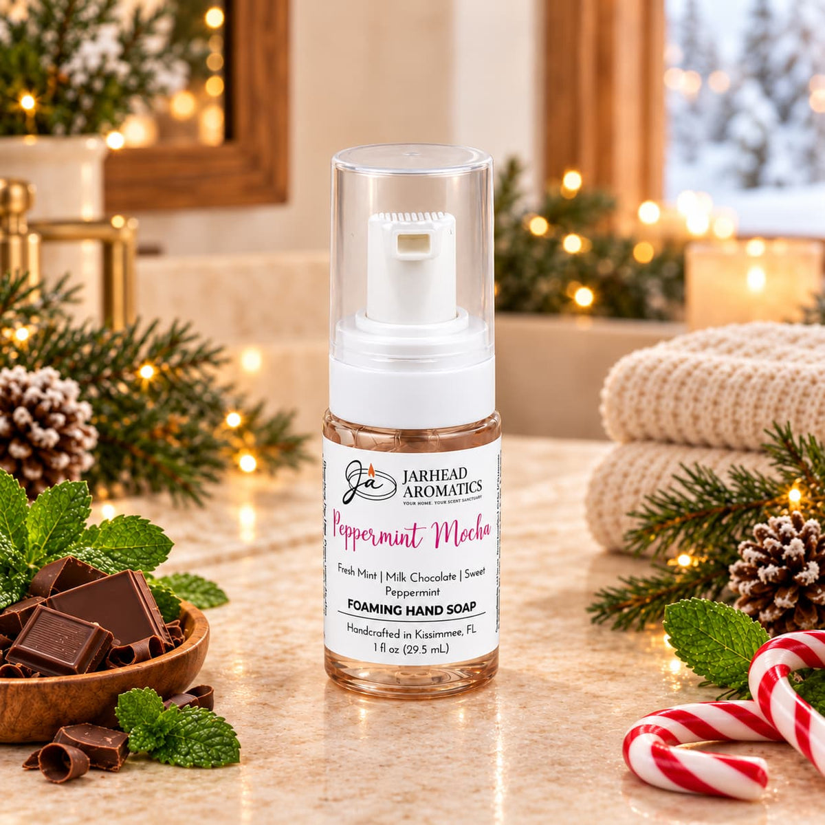 A bottle of Peppermint Mocha Handmade Foaming Hand Soap | Chocolate Mint & Vanilla on a counter, surrounded by chocolate squares, fresh mint leaves, and a candy cane.