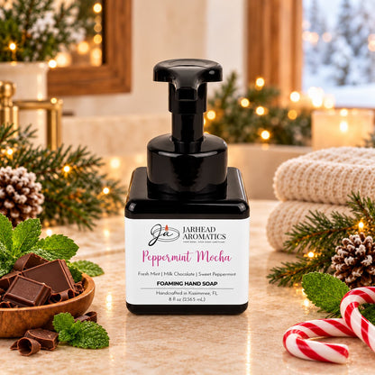 A square bottle of Peppermint Mocha Handmade Foaming Hand Soap | Chocolate Mint & Vanilla surrounded by chocolate squares, mint leaves, and candy canes.