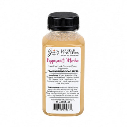 A bottle of Jarhead Aromatics Peppermint Mocha Handmade Foaming Hand Soap refill with a label listing ingredients, directions, and holiday scent notes of fresh mint, milk chocolate, and sweet peppermint.