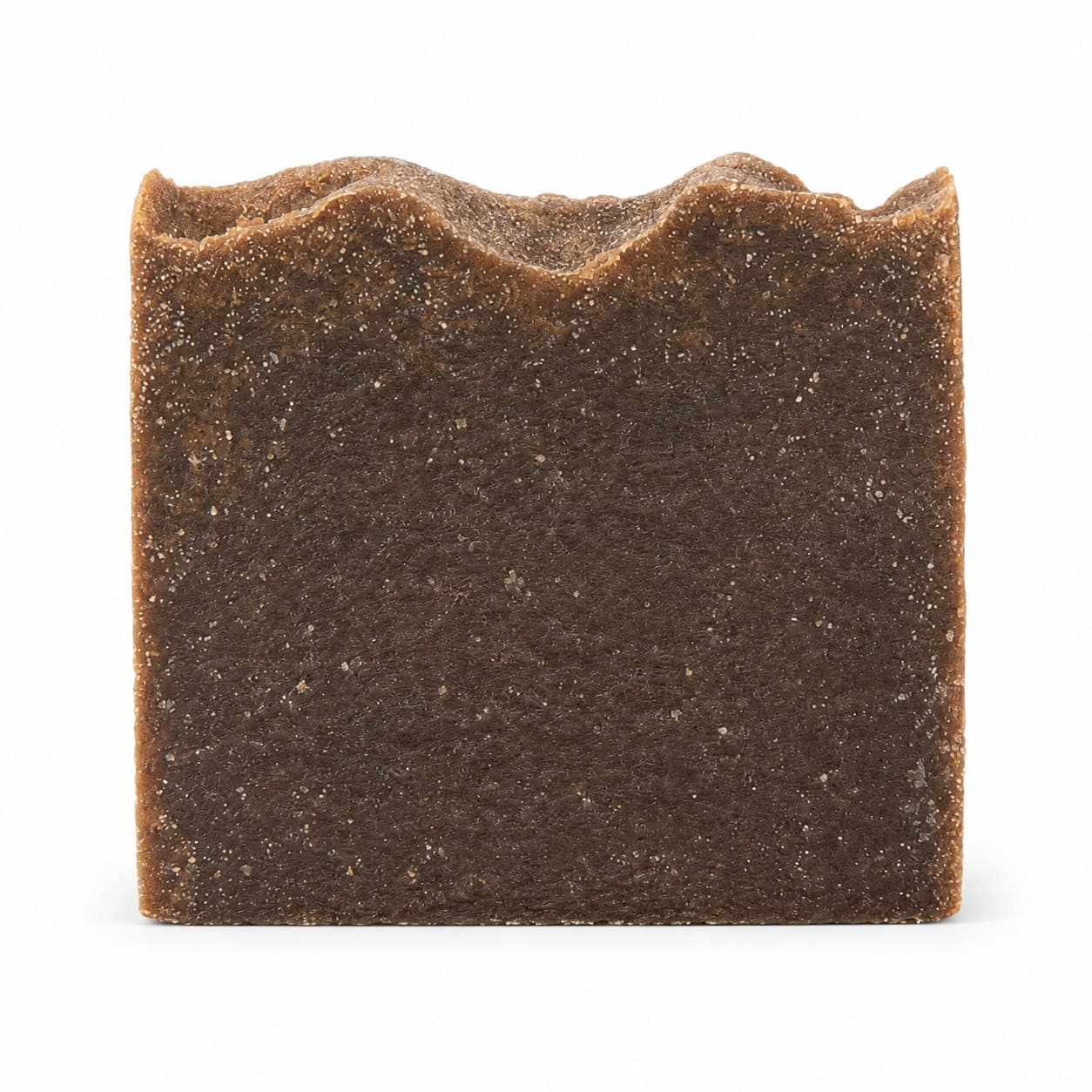 A rectangular bar of Jarhead Aromatics Pine Tar Handmade Natural Artisan Soap, featuring a rough, textured surface and an uneven, wavy top edge, is displayed against a plain white background.