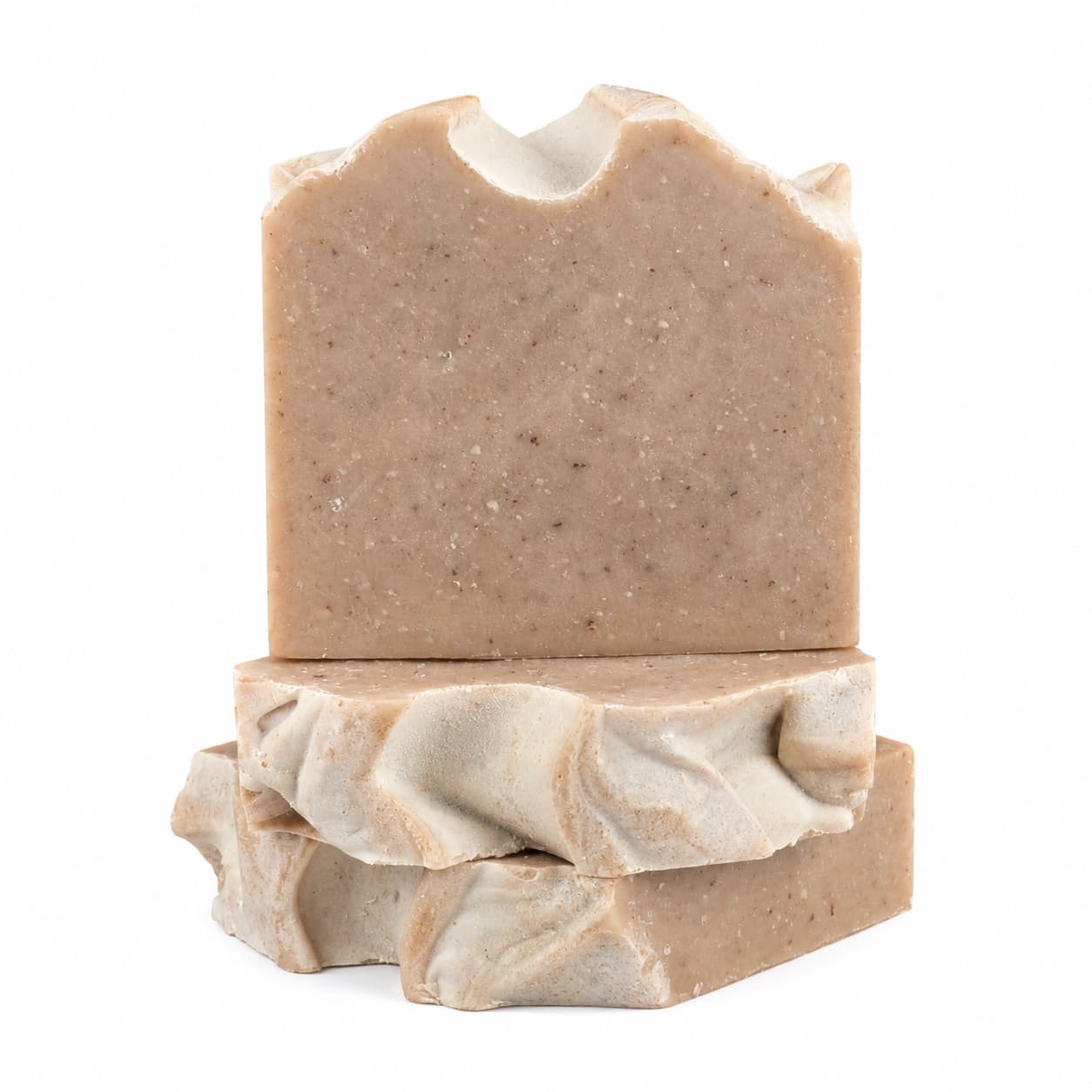 Three bars of Jarhead Aromatics’ Pumpkin + Spice Handmade Artisan Soap are stacked on a white background. The top bar of this spiced pumpkin exfoliating soap features a slightly jagged edge, while the two below showcase wavy, marbled textures. Each rustic brown bar is infused with the warm autumn fragrance signature to this handmade artisan collection.