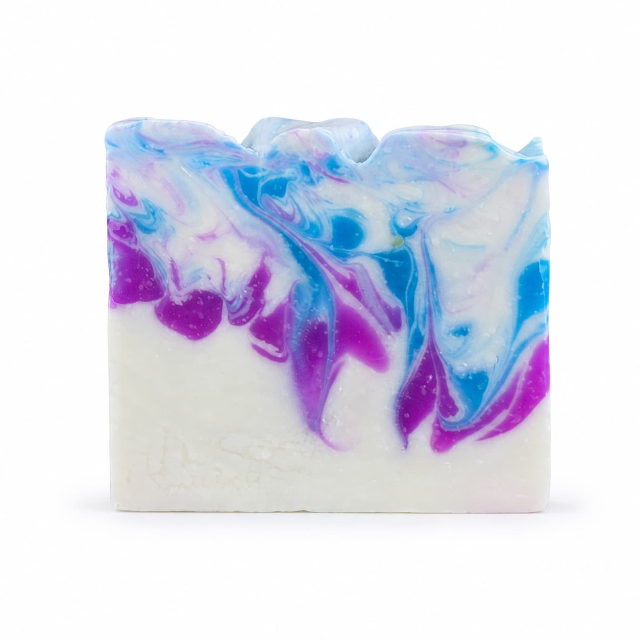 A bar of Raspberry + Vanilla Handmade Coconut Milk Artisan Soap from Jarhead Aromatics, featuring a white base with swirls of blue, purple, and pink on top that resemble waves or marble patterns.