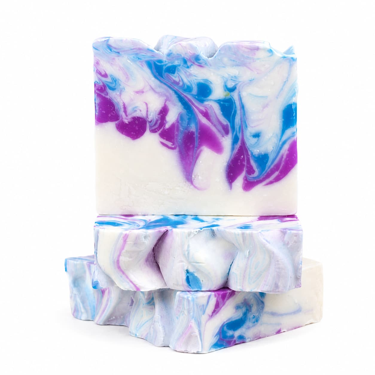 Three Raspberry + Vanilla Handmade Coconut Milk Artisan Soaps by Jarhead Aromatics, featuring a marbled pattern of blue, purple, and white, are stacked on a white background. These artisan bars showcase wavy, textured tops and a smooth finish.