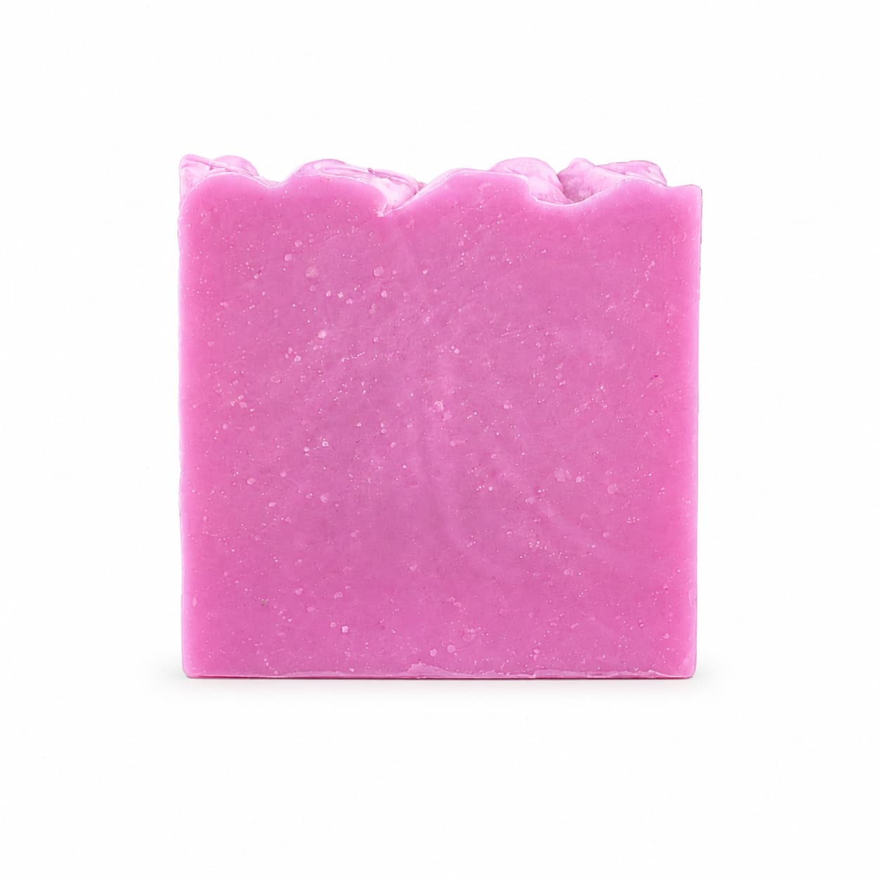 A rectangular bar of Rose + Hibiscus Handmade Coconut Milk Artisan Soap by Jarhead Aromatics, featuring a slightly wavy top edge and displayed against a plain white background.