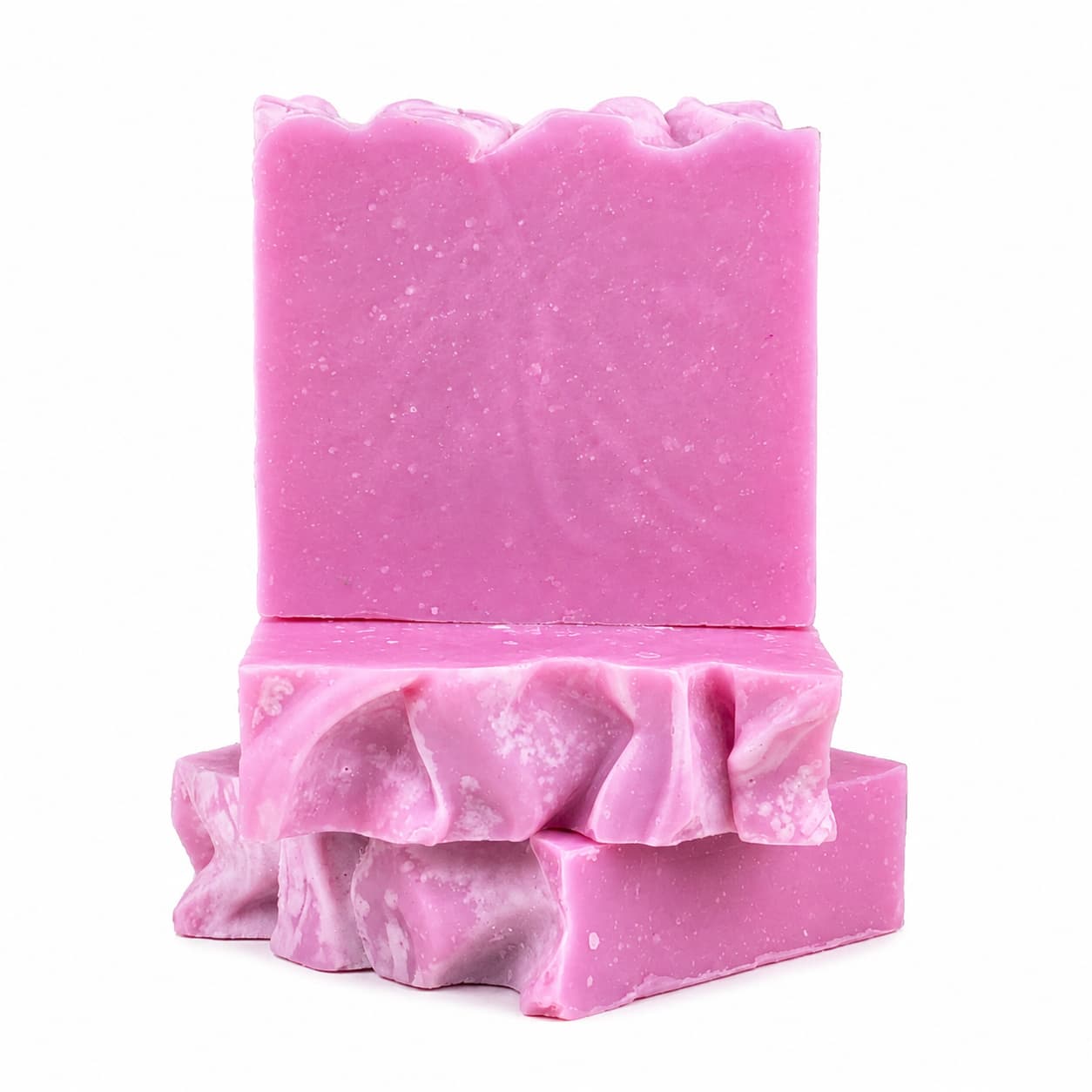 Two vibrant pink Rose + Hibiscus Handmade Coconut Milk Artisan Soap bars by Jarhead Aromatics stand out—one displayed upright, with two more stacked flat beneath it. These romantic floral soaps feature wavy, textured tops and marbled white streaks along the sides.