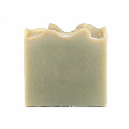 A rectangular bar of Tea Tree Handmade Natural Goat Milk Artisan Soap by Jarhead Aromatics, featuring a greenish hue and uneven, wavy top edges, set against a plain white background.