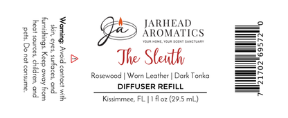 Label for Jarhead Aromatics’ “The Sleuth” Car Diffuser Refill – a masculine air freshener with leather, sandalwood, and patchouli. 1 fl oz. Warning: avoid eye/skin contact. Barcode on the right.