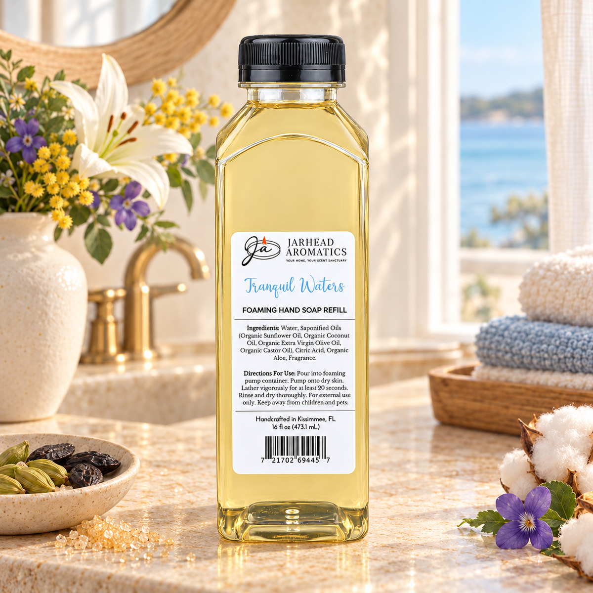 A clear plastic bottle of Tranquil Waters Handmade Foaming Hand Soap | Marine, Lily & Tonka Bean coastal fragrance refill featuring a label with product ingredients and usage instructions.