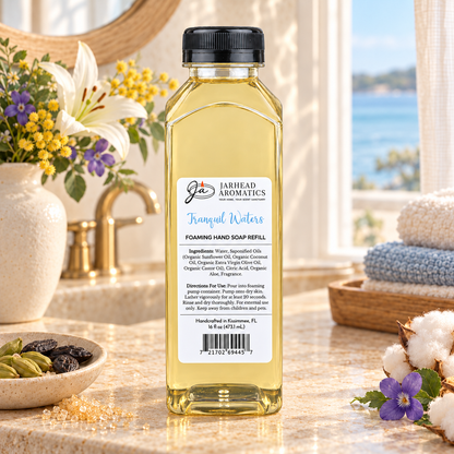A clear plastic bottle of Tranquil Waters Handmade Foaming Hand Soap | Marine, Lily & Tonka Bean coastal fragrance refill featuring a label with product ingredients and usage instructions.
