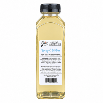 A clear plastic bottle of Tranquil Waters Handmade Foaming Hand Soap | Marine, Lily & Tonka Bean refill with a black cap and a rectangular label listing ingredients, directions, and a barcode.