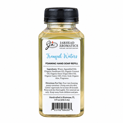 Small clear plastic bottle of Tranquil Waters Handmade Foaming Hand Soap | Marine, Lily & Tonka Bean refill with a black cap and a white label listing ingredients, directions, and a barcode.