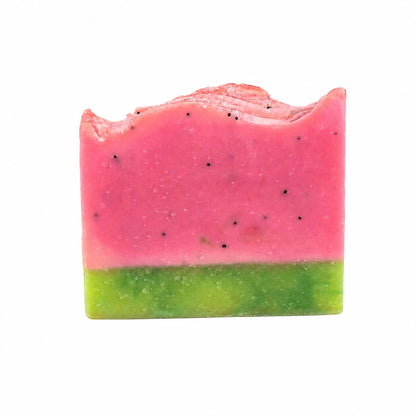 A bar of Watermelon + Mint Handmade Artisan Soap by Jarhead Aromatics, crafted to look like a watermelon slice with a pink top layer dotted with black specks and a green bottom layer, displayed against a white background.