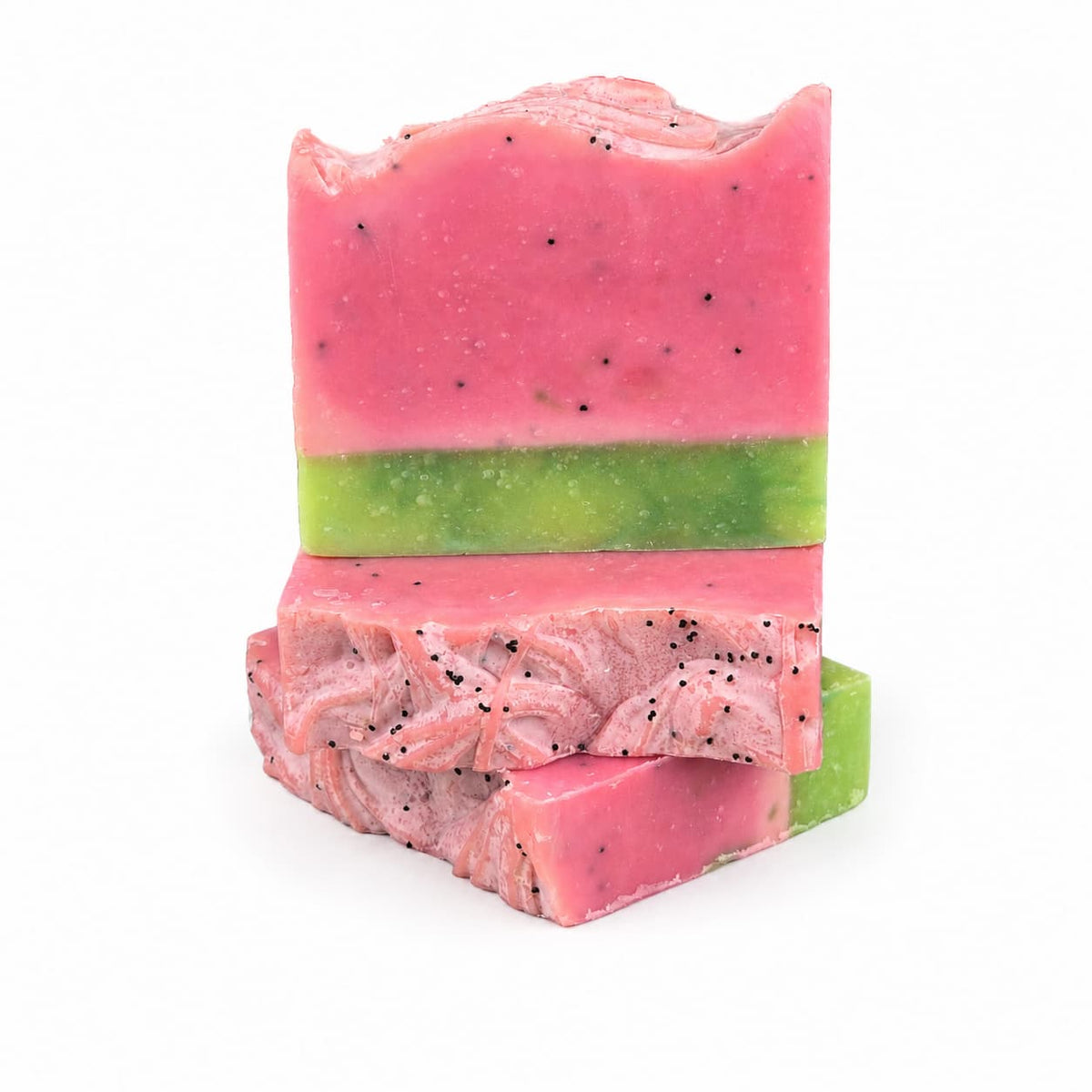 Two Jarhead Aromatics Watermelon + Mint Handmade Artisan Soaps, expertly crafted to resemble watermelon slices with vibrant pink tops, refreshing green middles, and delicate black specks for seeds, are stacked against a white background.