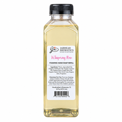 A clear plastic bottle of Jarhead Aromatics Whispering Rose Handmade Foaming Hand Soap refill with a black cap and a label detailing the ingredients, directions, and a barcode.
