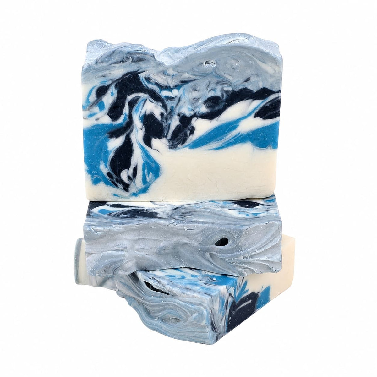 Three stacked bars of Winter Wonderland Handmade Coconut Milk Artisan Soap, featuring a blue, black, and white marbled swirl pattern.