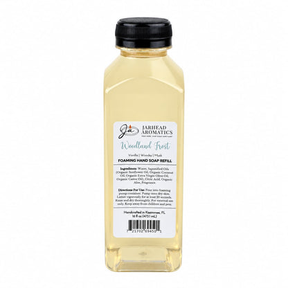 Clear plastic bottle of Woodland Frost Handmade Foaming Hand Soap | Vanilla, Lavender & Woodsy Musk with a black cap and a rectangular label detailing ingredients, directions, and a barcode.